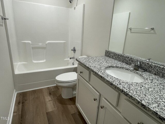 full bathroom featuring shower / bathing tub combination, hardwood / wood-style flooring, vanity, and toilet