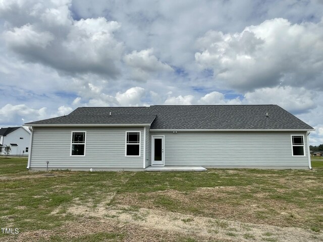 back of house with a lawn and a patio