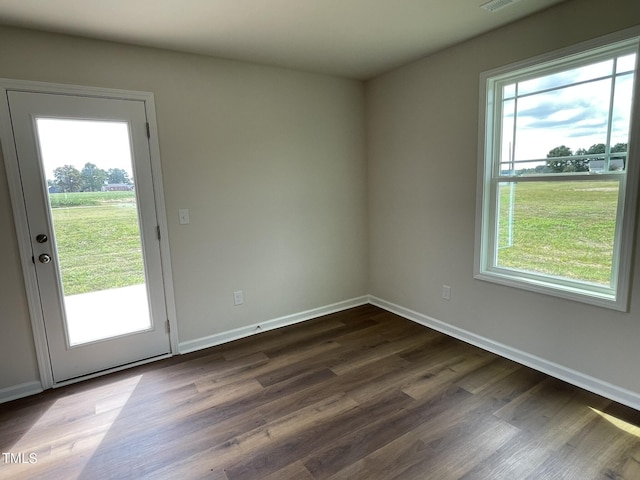 spare room featuring dark wood-style floors, baseboards, and visible vents