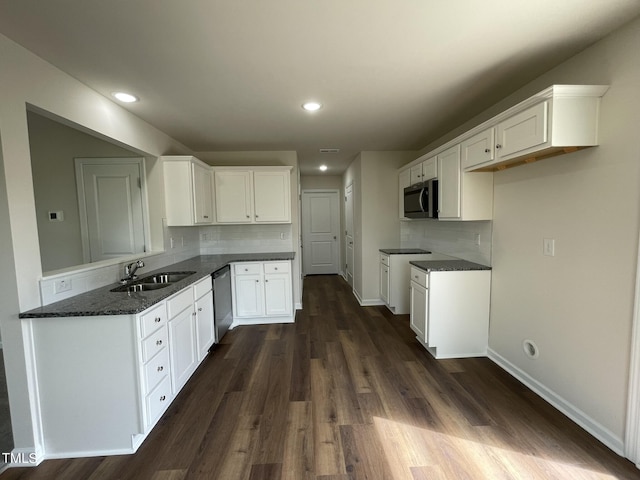 kitchen with decorative backsplash, a sink, stainless steel appliances, and dark wood finished floors