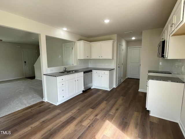 kitchen with dark wood-type flooring, sink, appliances with stainless steel finishes, and white cabinets