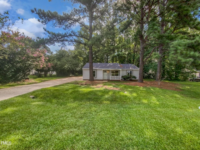 single story home featuring covered porch, a front lawn, and concrete driveway