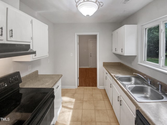 kitchen with under cabinet range hood, a sink, white cabinetry, baseboards, and black appliances