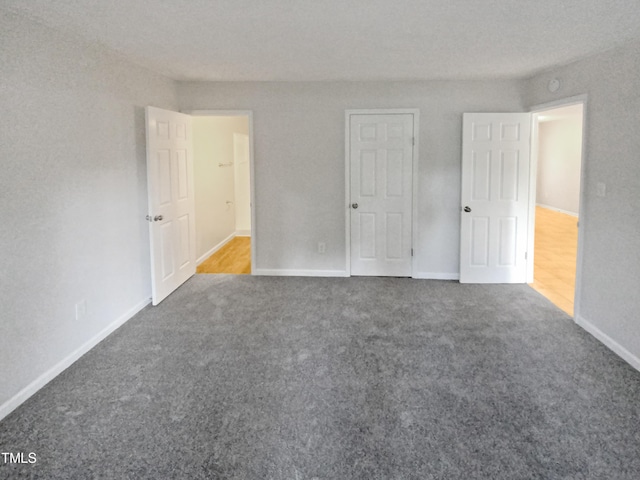 unfurnished bedroom featuring carpet floors and baseboards