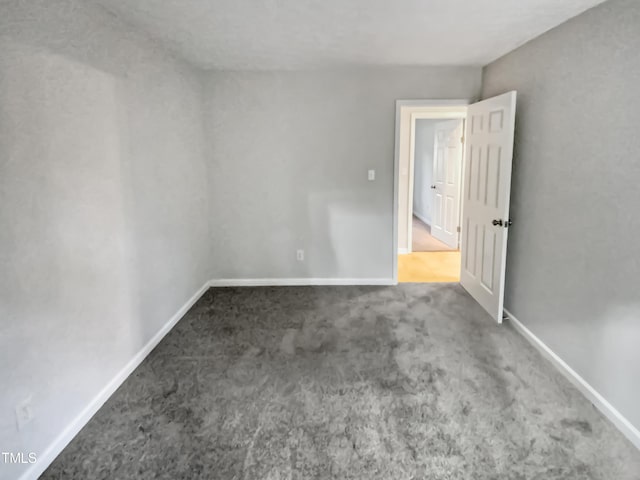 carpeted spare room with baseboards