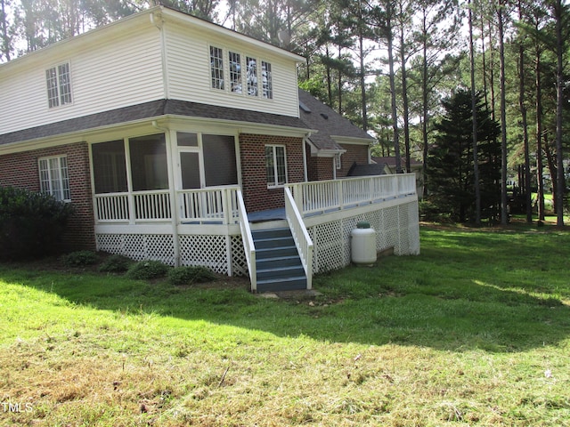 rear view of property with a deck and a lawn