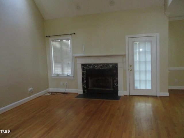 unfurnished living room featuring hardwood / wood-style floors, a wealth of natural light, and a premium fireplace