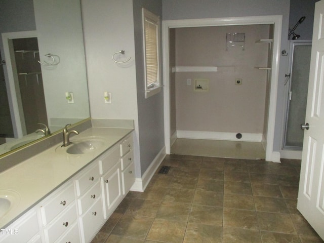 bathroom featuring tile patterned flooring, a shower with door, and vanity