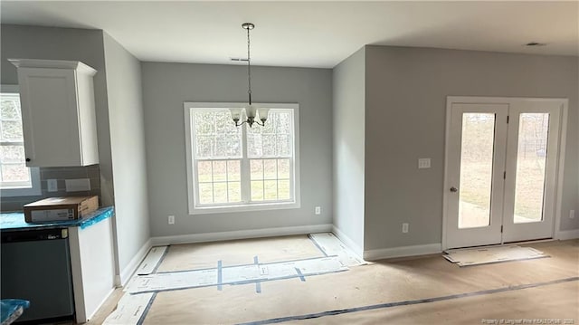 interior space with baseboards, a chandelier, and a wealth of natural light