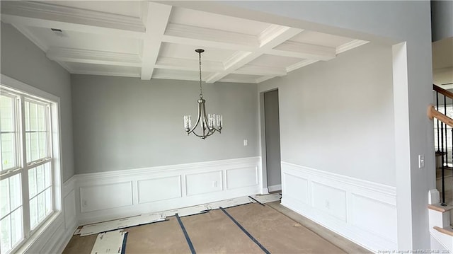 unfurnished dining area with coffered ceiling, a wealth of natural light, and beamed ceiling