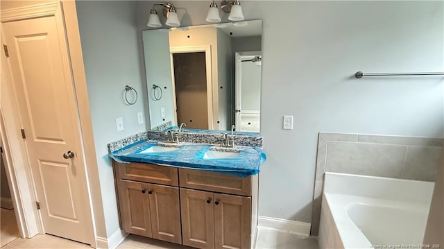 full bathroom featuring a washtub, a sink, baseboards, and double vanity