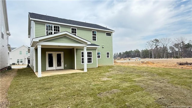 rear view of house with a patio area and a lawn