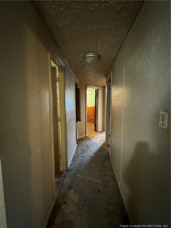 hall featuring a textured ceiling