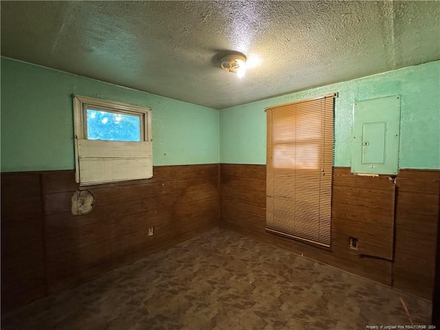 spare room with a textured ceiling and electric panel