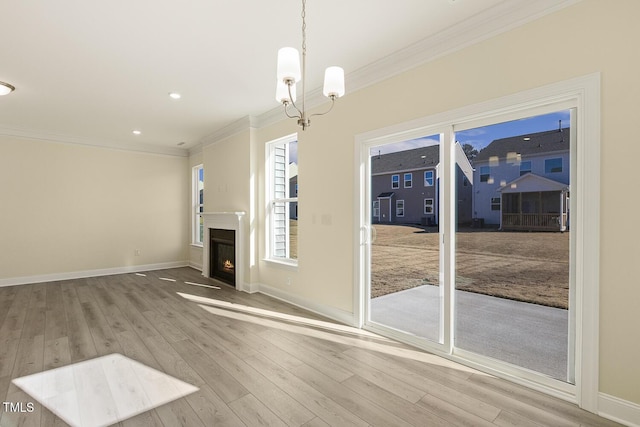 unfurnished living room with wood-type flooring, crown molding, and a notable chandelier