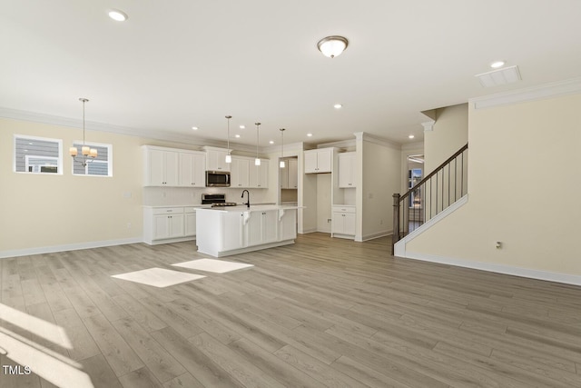 unfurnished living room featuring sink, a chandelier, light wood-type flooring, and crown molding