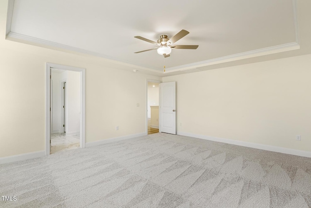 unfurnished room with ceiling fan, crown molding, light carpet, and a raised ceiling