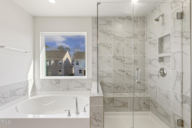 bathroom featuring shower with separate bathtub