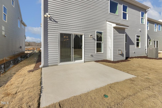 rear view of house with central AC unit and a patio