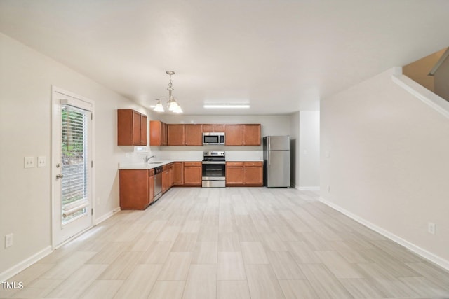 kitchen featuring a chandelier, stainless steel appliances, sink, and hanging light fixtures