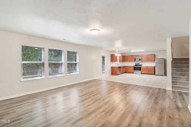 unfurnished living room featuring light hardwood / wood-style floors and a textured ceiling