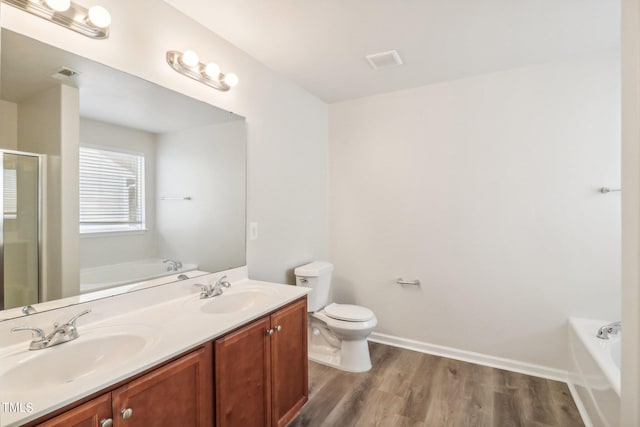 full bathroom with vanity, toilet, wood-type flooring, and plus walk in shower