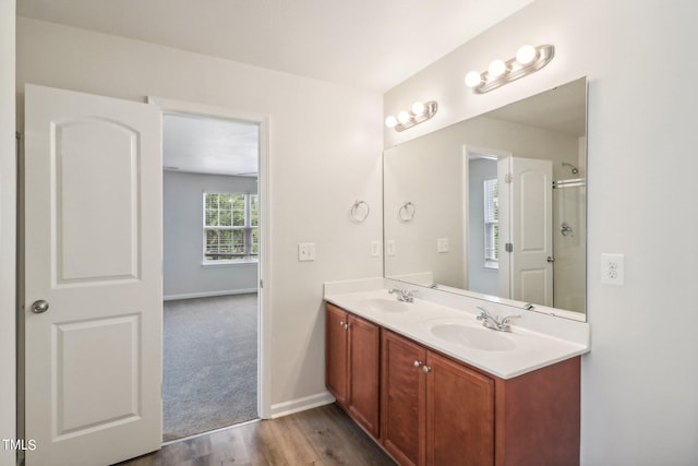 bathroom featuring a shower with shower door, wood-type flooring, and vanity