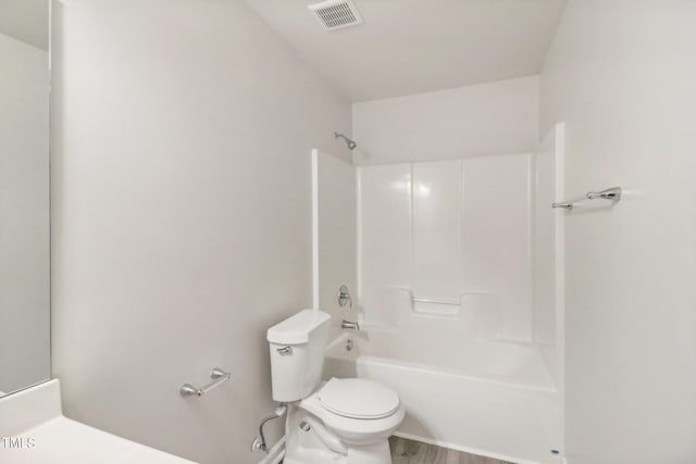 bathroom with toilet, washtub / shower combination, and hardwood / wood-style floors