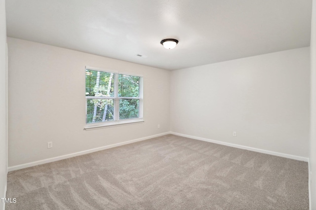 spare room featuring light colored carpet