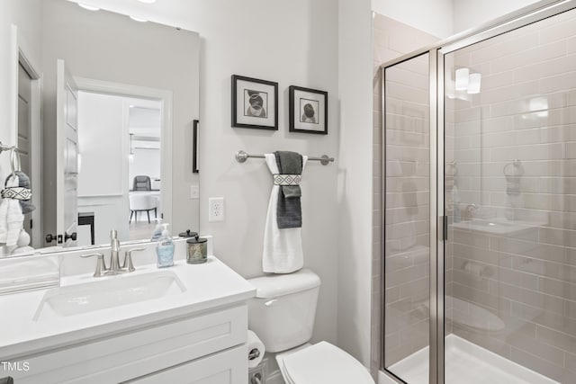 full bath with a stall shower, vanity, and toilet