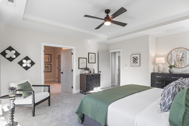 bedroom featuring visible vents, a tray ceiling, and light colored carpet