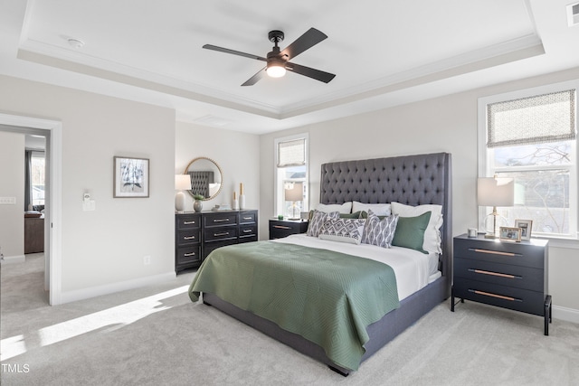 bedroom with a tray ceiling, multiple windows, and visible vents