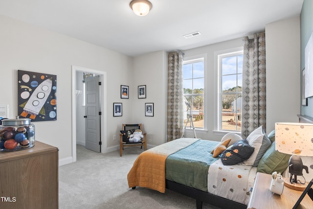 bedroom with baseboards, visible vents, and light colored carpet