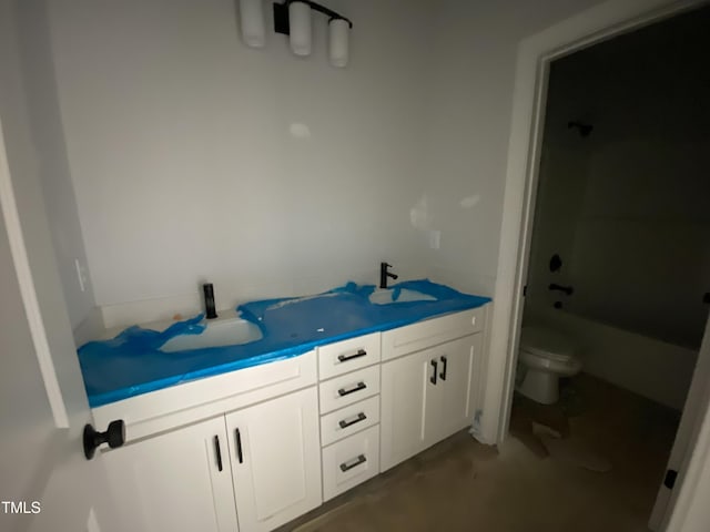 full bathroom featuring shower / tub combination, a sink, toilet, and double vanity