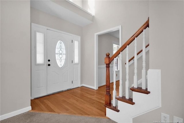 foyer with stairs, baseboards, and wood finished floors