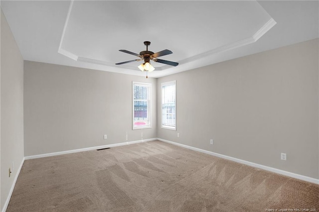 unfurnished room featuring carpet, a raised ceiling, and baseboards