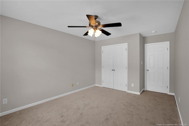 unfurnished bedroom with a closet, carpet, a ceiling fan, and baseboards