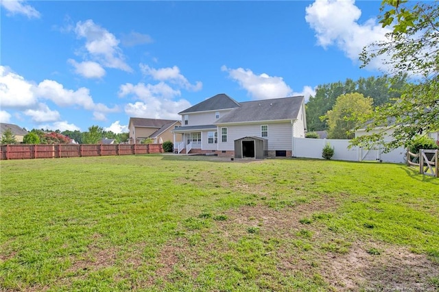 back of property featuring an outbuilding, a fenced backyard, and a lawn