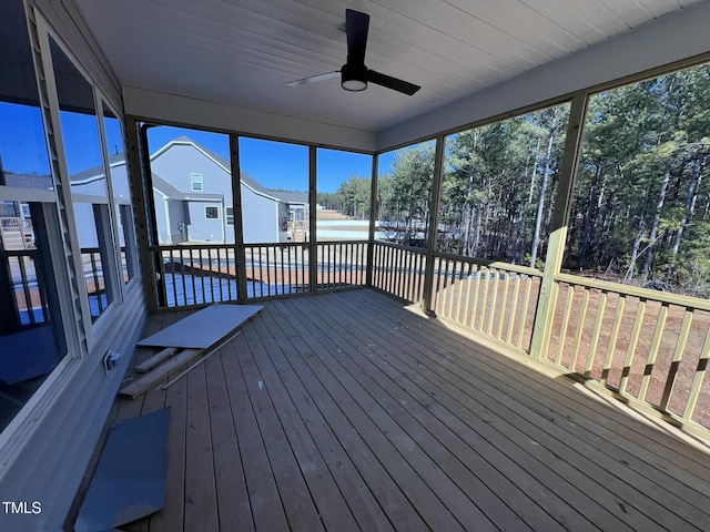 unfurnished sunroom featuring ceiling fan