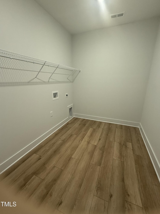 washroom featuring dark wood-style flooring, visible vents, electric dryer hookup, laundry area, and baseboards