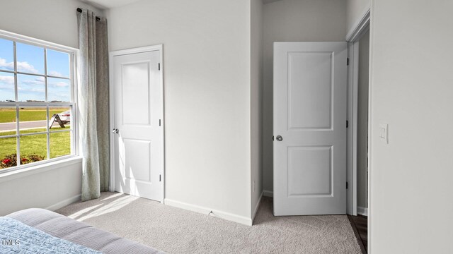 carpeted bedroom featuring multiple windows