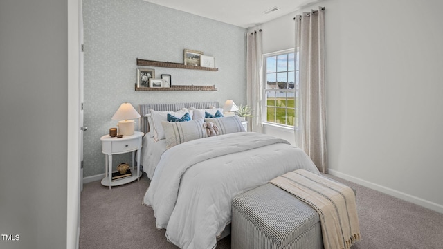 carpeted bedroom with visible vents, wallpapered walls, and baseboards