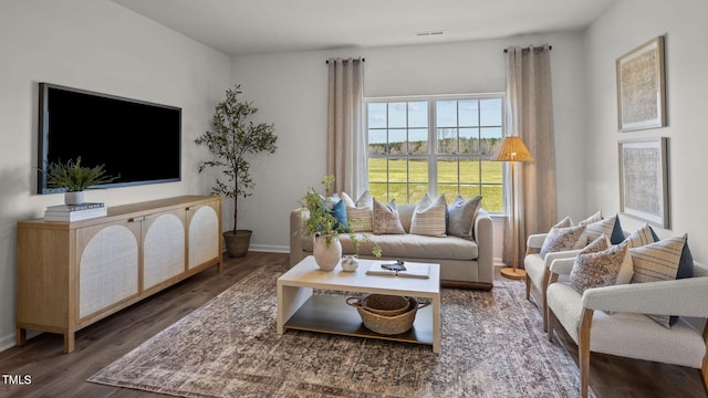 living room featuring visible vents, wood finished floors, and baseboards