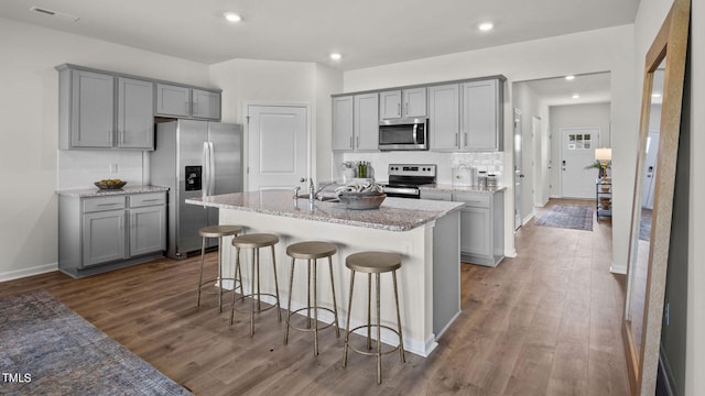 kitchen with appliances with stainless steel finishes, dark wood-style flooring, and gray cabinets