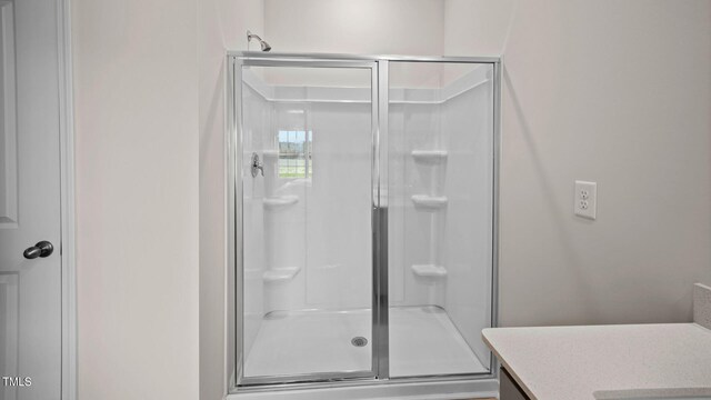 bathroom with vanity and a shower with shower door