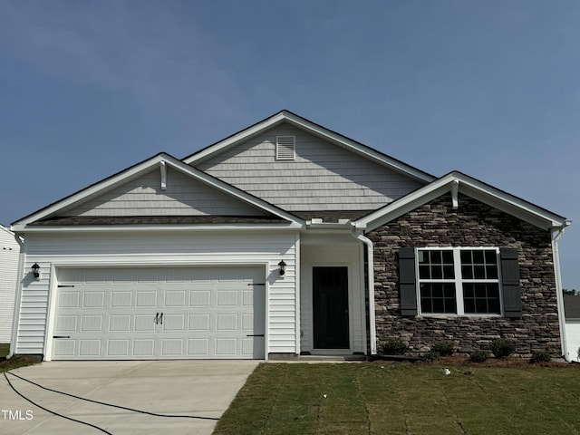 craftsman-style home with concrete driveway, a garage, and a front yard