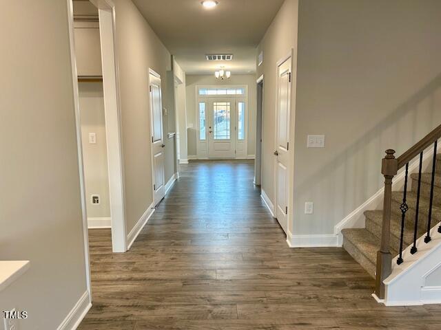 interior space featuring dark hardwood / wood-style flooring and an inviting chandelier