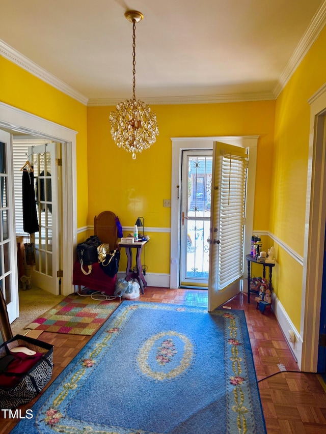 entryway with baseboards, ornamental molding, a chandelier, and french doors