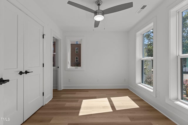 unfurnished room with ceiling fan and wood-type flooring