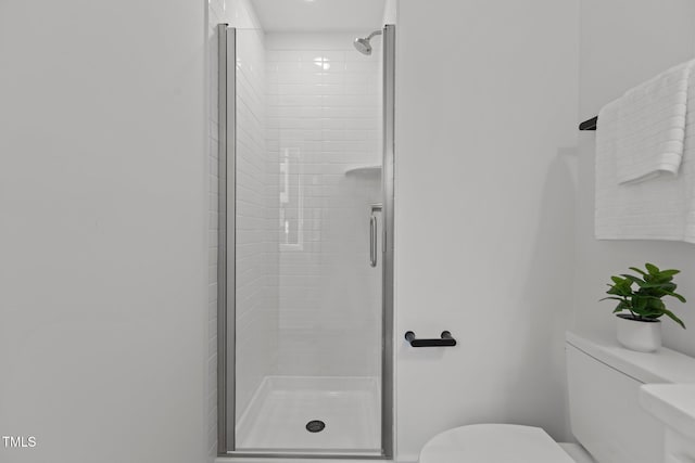 bathroom featuring an enclosed shower and toilet